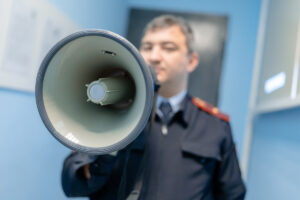 полицейский держит рупор в руках