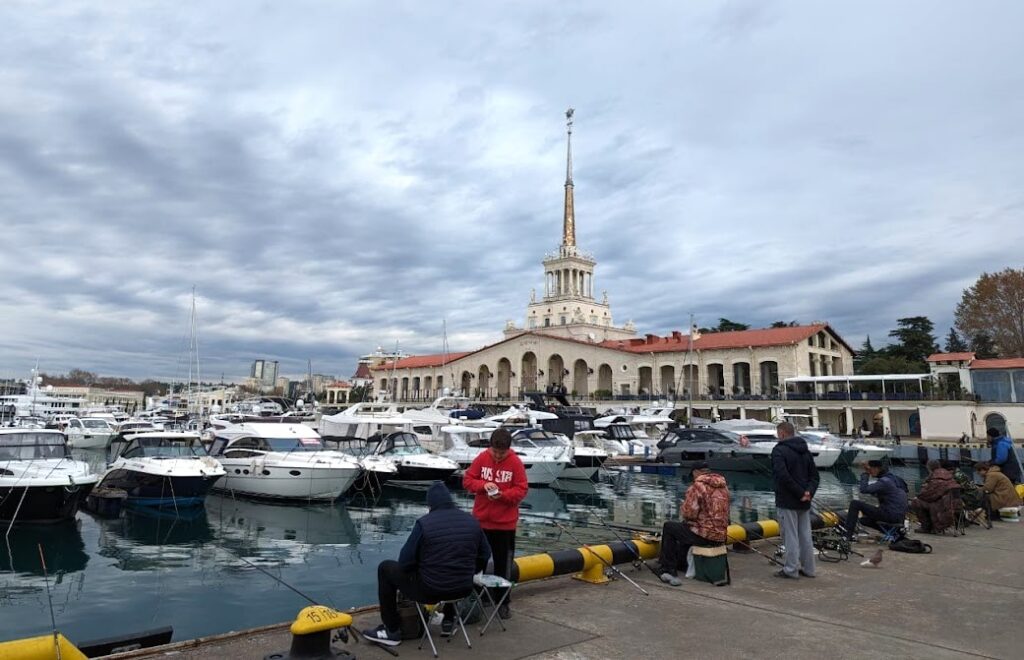 рыбаки сидят в порту Сочи