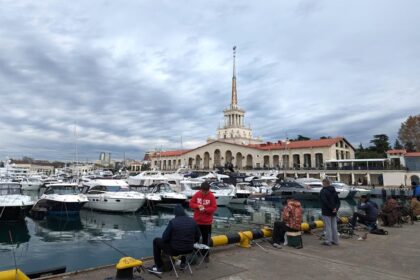 рыбаки сидят в порту Сочи
