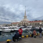 рыбаки сидят на пирсе морпорта Сочи