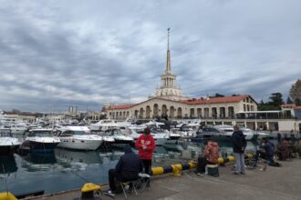 рыбаки сидят на пирсе морпорта Сочи