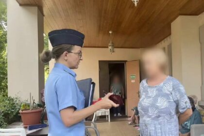 пристав стоит с женщиной во дворе дома