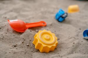 игрушки лежат на песке
