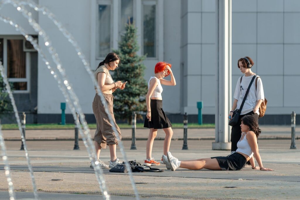 подростки стоят у фонтана