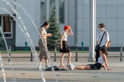подростки стоят у фонтана