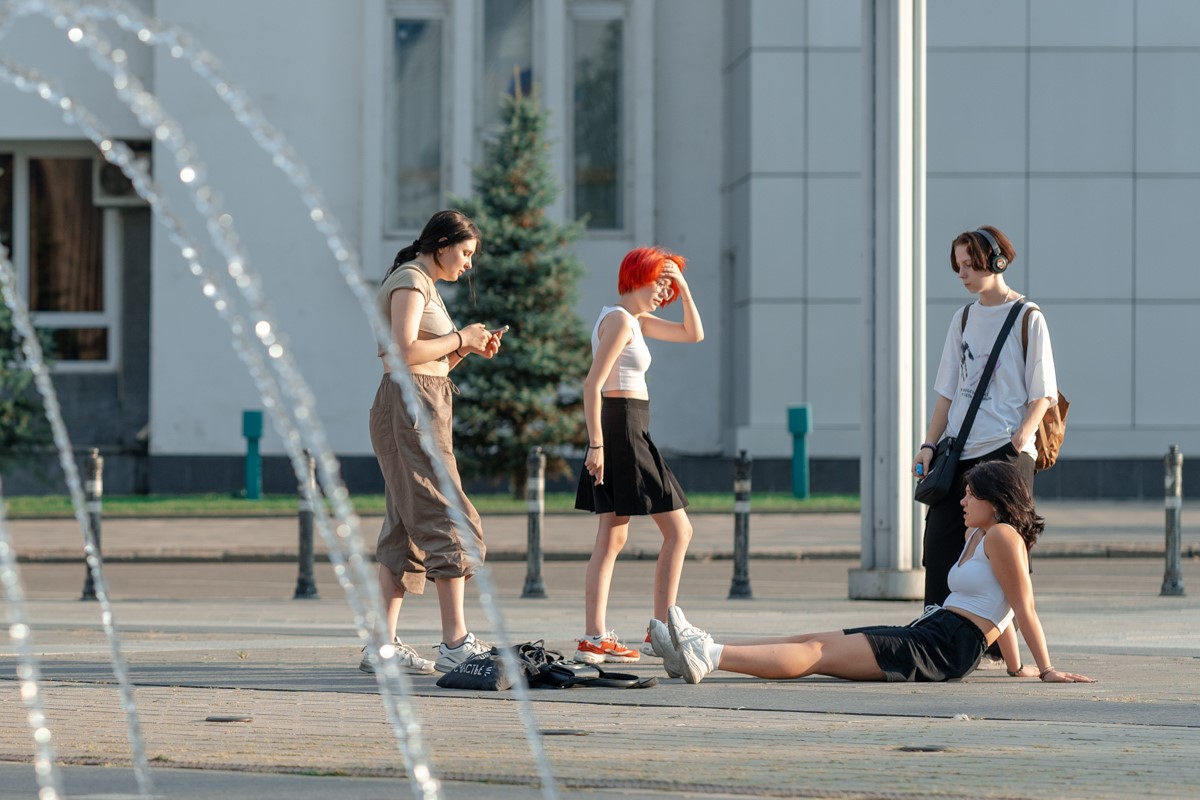 подростки стоят у фонтана