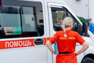 врач стоит около скорой помощи